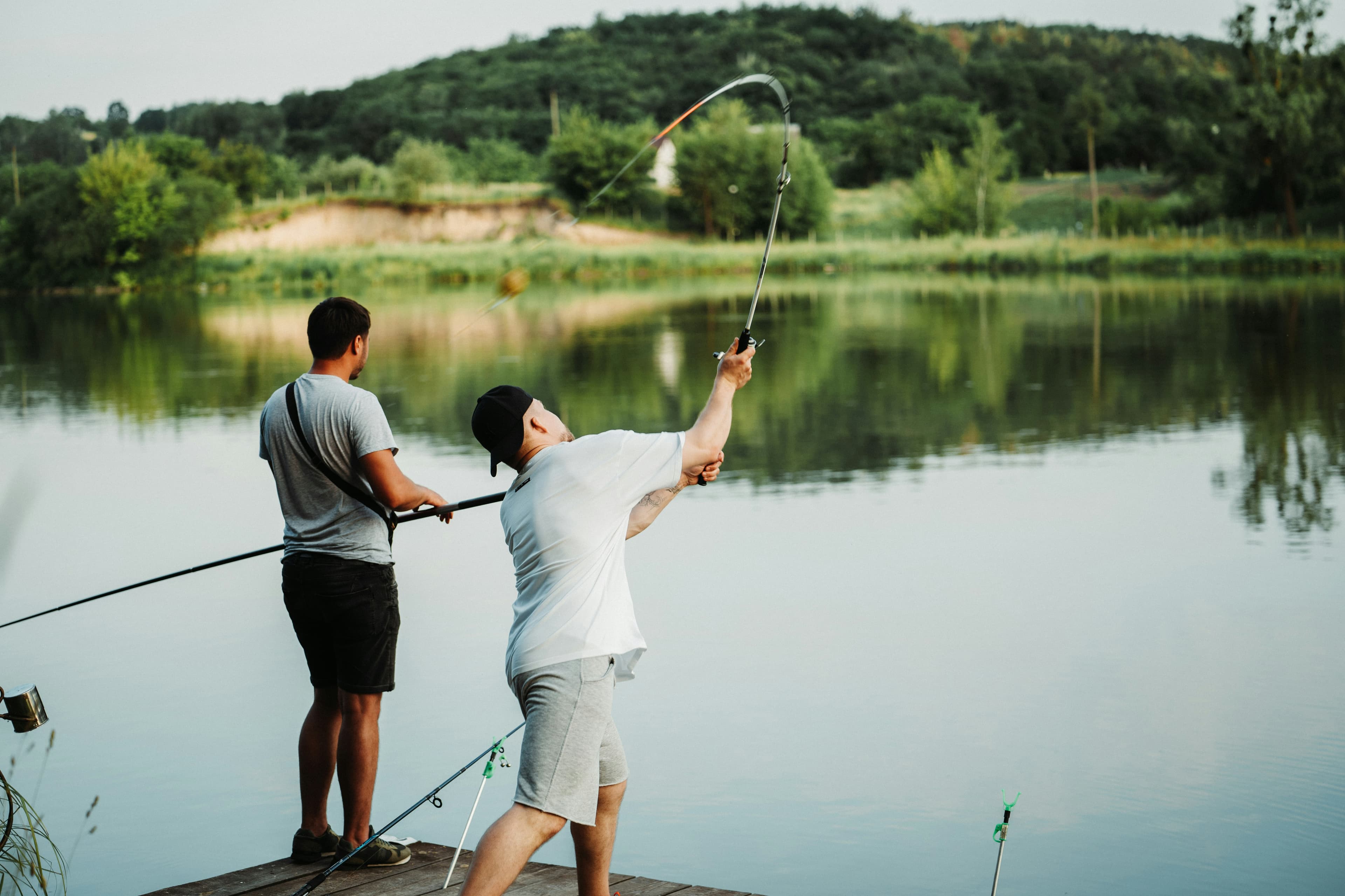 An angler casting a long line from the bank at sunrise