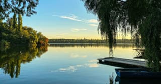 A misty Romanian carp lake at sunrise with rods on the bank